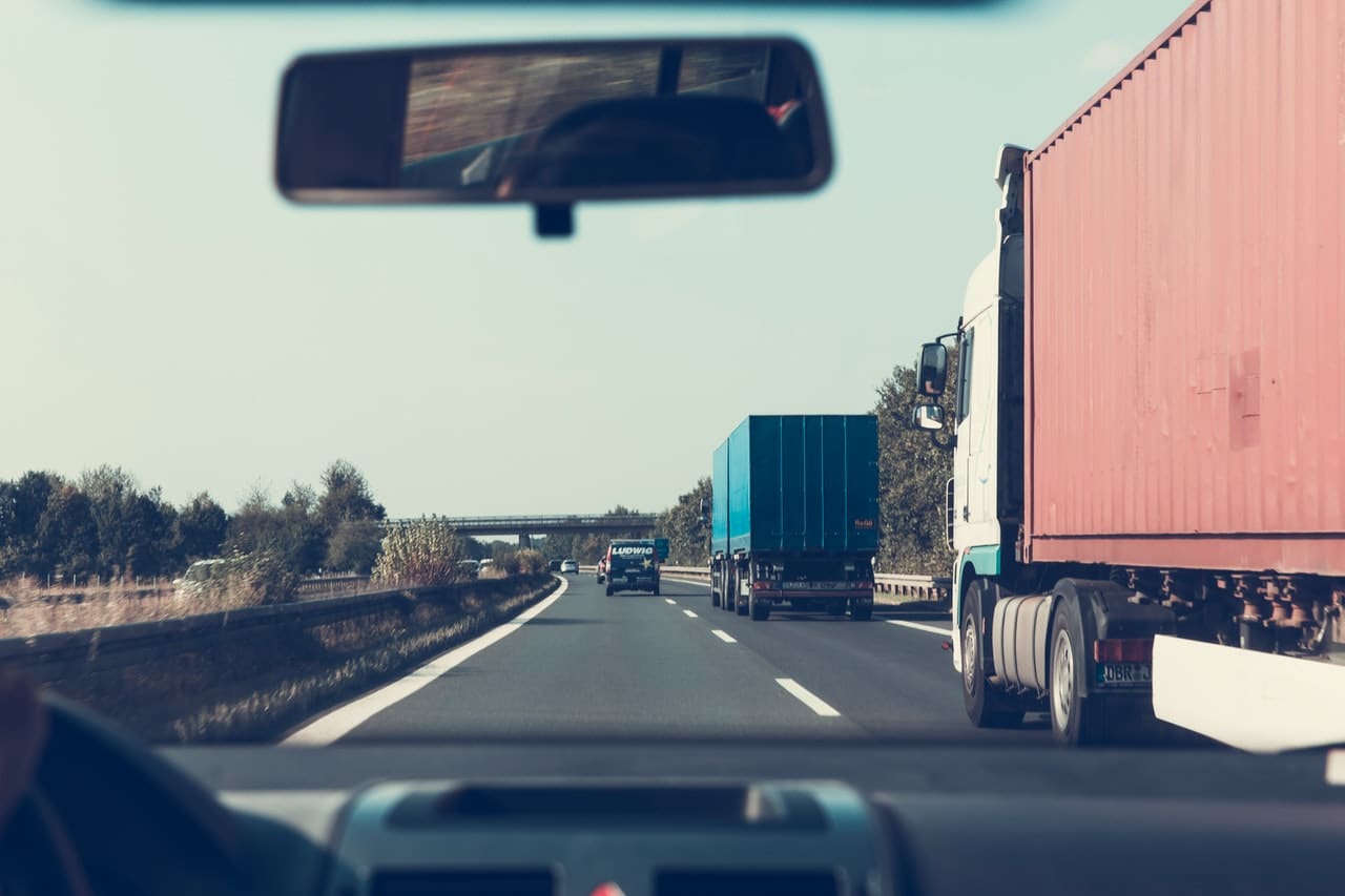 Big rig truck on the highway viewed through the windshield of a car