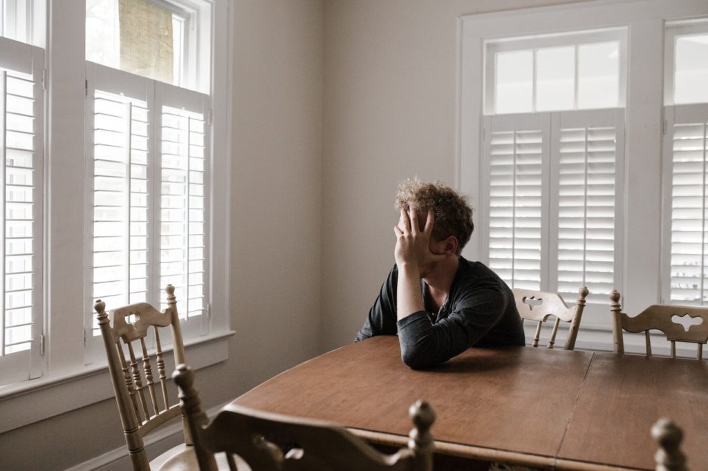 Man with pain and suffering sitting at a table